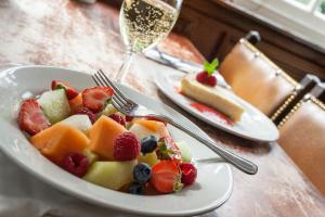 un plato de fruta en una mesa con una copa de vino en The Shandwick Inn, en Tain