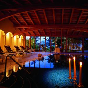 Habitación con piscina con sillas y velas en Schloss Hotel Korb, en Appiano sulla Strada del Vino