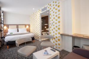 a hotel room with a bed and a living room at Holiday Inn Paris Opéra - Grands Boulevards, an IHG Hotel in Paris