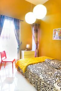 a bedroom with a bed and a chair and a window at Tropical Boutique Batu Villa, Near Museum Angkut in Batu