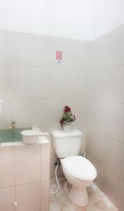 a white bathroom with a toilet and a plant on it at Tropical Boutique Batu Villa, Near Museum Angkut in Batu +30 photos