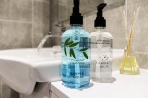 two bottles of water sitting on top of a sink at Stylish - Modern - Serviced Accommodation - In The Heart of Northumberland in Ashington +41 photos