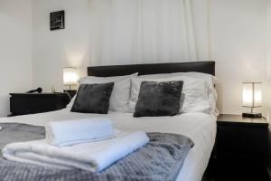a bed with white blankets and pillows on it at Stylish - Modern - Serviced Accommodation - In The Heart of Northumberland in Ashington