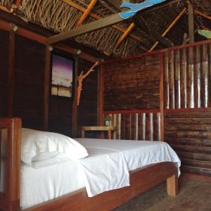 1 dormitorio con 1 cama y TV. en Cabañas Refugio Salomon en Nuquí