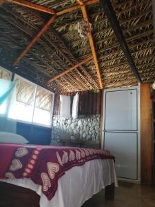 a room with a bed and a refrigerator in it at Cabañas Refugio Salomon in Nuquí