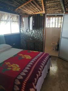 a bedroom with a bed with a red blanket at Cabañas Refugio Salomon in Nuquí