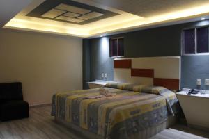 sypialnia z łóżkiem z żółtą narzutą i pokój ze stołem w obiekcie Hotel Love w mieście Temixco
