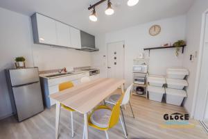 a kitchen with a wooden table and yellow chairs at GLOCE 逗子ワーケーションハウス なぎさ l ZUSHI Workcation House NAGISA in Zushi