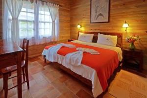 a bedroom with a large bed in a wooden room at Finca Hamburgo La Ruta del Cafe in Tapachula