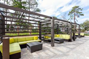 une pergola avec des canapés jaunes sur une terrasse dans l'établissement Holiday Inn - Tallahassee E Capitol - Univ, an IHG Hotel, à Tallahassee