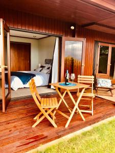 a bedroom with a bed and a table and chairs on a deck at Lake View Garden Apartment in Taupo