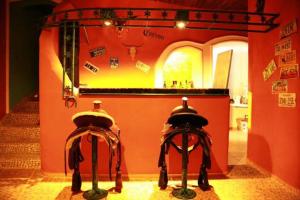 two horse saddles in a room with a counter at Hotel La Hasienda in Kupang