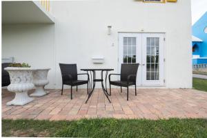 a table and chairs on a brick patio at Windsong Guest Apartments in Pembroke