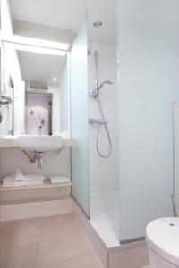 a bathroom with a shower, toilet and sink at Kyriad Deauville - St Arnoult in Deauville