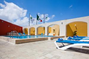 una piscina con sedie blu e bandiere in un edificio di Holiday Inn Puebla La Noria, an IHG Hotel a Puebla