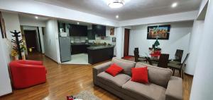 a living room with a couch and a table and a kitchen at Cusco Apartment MVP in Cusco
