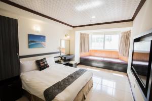pokój hotelowy z łóżkiem i dużym oknem w obiekcie Kenting Maldives Hotspring Hotel w mieście Hengchun Old Town