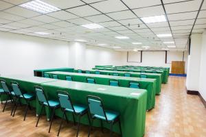 una sala de conferencias con mesas verdes y sillas en Kenting Maldives Hotspring Hotel, en Hengchun