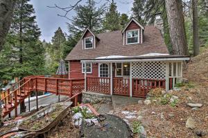 une maison rouge avec une terrasse dans les bois dans l'établissement Vintage Snow White Cottage about 2 Miles to Village!, à Lake Arrowhead