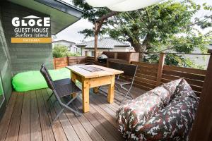 un patio con mesa y sillas en una terraza en GLOCE 葉山 サーファーズログハウス l HAYAMA Surfers Log house en Hayama