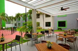 un patio avec des tables et des chaises et un bâtiment dans l'établissement Holiday Inn Tampico-Altamira, an IHG Hotel, à Tampico