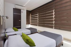 メデジンにあるAyenda 1254 Mi Colombiaのベッドルーム1室(ベッド2台、窓付)