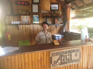 a woman standing behind a counter in a restaurant at Ana Warung & Bungalows in Gili Meno