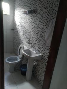 a bathroom with a toilet and a sink at Pousada da Ana in Cavalcante