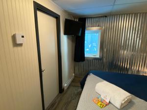 a small room with a bed and a window at Dawson Lodge in Dawson City