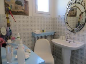 een badkamer met een wastafel en een stoel naast een wastafel bij La Clorinde in Moustiers-Sainte-Marie