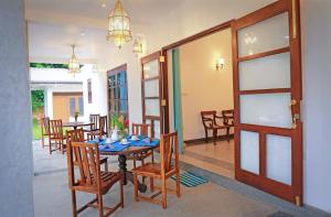 uma sala de jantar com uma mesa e cadeiras e uma porta em Green Residencies em Galle