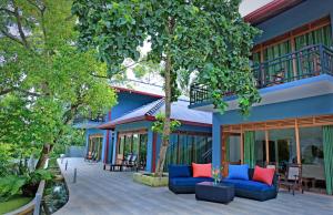 a patio with blue couches in front of a building at Green Residencies in Galle