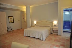 a bedroom with a white bed and a large window at Il Casale Della Stella in Baronissi