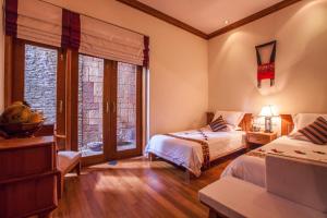 a bedroom with two beds and a window at The Hotel by the Red Canal in Mandalay +68 photos