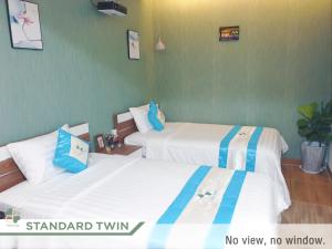 2 camas en una habitación con paredes verdes en FLORA Hotel Phu Quoc en Phu Quoc