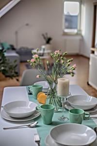 uma mesa com pratos e copos e um vaso com flores em Apartament Miętowy z 2 sypialniami i miejscem parkingowym em Kielce