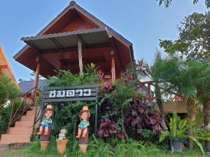 a sign in front of a house with plants at Khao Kho Lucky Hill Resort in Khao Kho