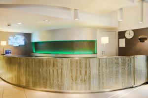a hotel lobby with a reception counter and a large screen at Turin City Centre in Turin