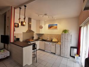 a kitchen with white cabinets and a refrigerator at La Grillotte in Vieux-Boucau-les-Bains