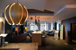 a lobby with chairs and a table in a room at Holiday Inn - Salzburg City by IHG in Salzburg