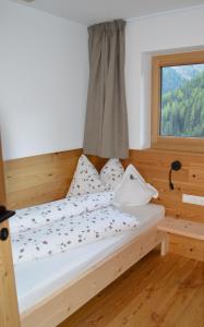 a bed in a room with a window at Steinhof in Val di Mezzo