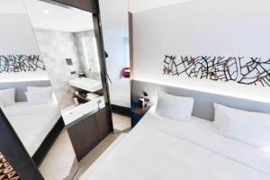 a bedroom with two beds and a mirror at Radisson Blu Hotel, Bruges in Bruges