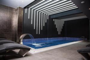 een badkamer met een zwembad met een kroonluchter bij Mugwort Hotel & Spa in Istanbul