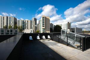 three chairs on a roof with a city skyline at Skyvillion - Olympic View London Stratford Apartment in London