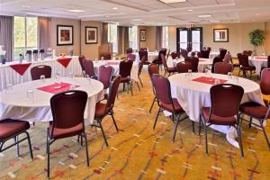 uma sala de banquetes com mesas e cadeiras brancas em Holiday Inn Express Hotel & Suites Albany, an IHG Hotel em Albany