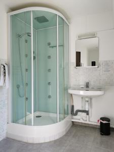 a bathroom with a glass shower and a sink at Le Saint Jean in Barbentane