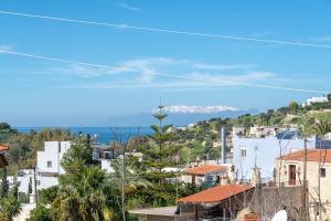 a view of a city with the ocean in the background at Apartment Mariandi in Pitsidia