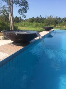 a pool of blue water with a stone fountain at Captain's Cabin Resort - Naval Heritage (Swimming Pool) in Kota Bharu