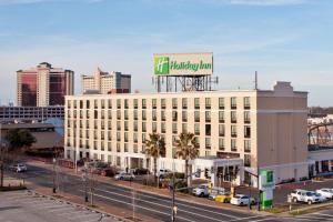 a large white building with a sign on top of it at Holiday Inn Shreveport Downtown by IHG in Shreveport