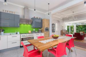 a kitchen with a wooden table and red chairs at SARAH's PLACE- MANOR HOUSE in George
